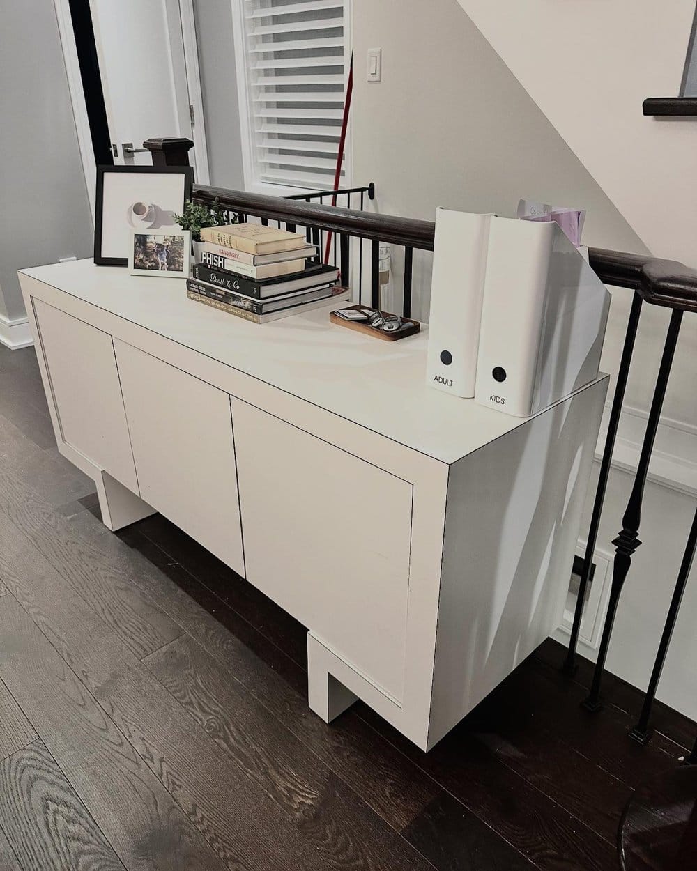 White console styled with books and labelled adult and kids paper files