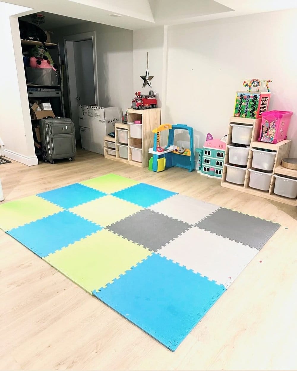 Basement playroom with a foam play mat and organized toy storage bins