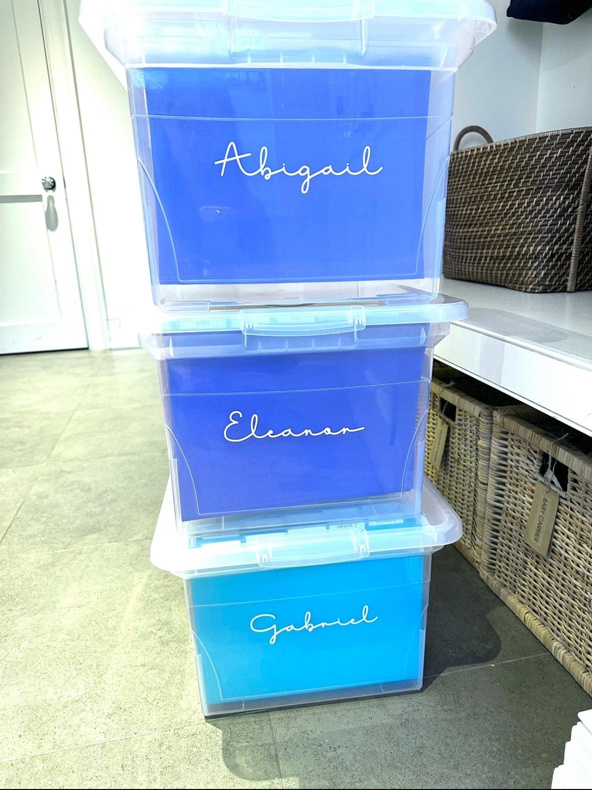 Stacked clear keepsake bins labelled Abigail, Eleanor and Gabriel