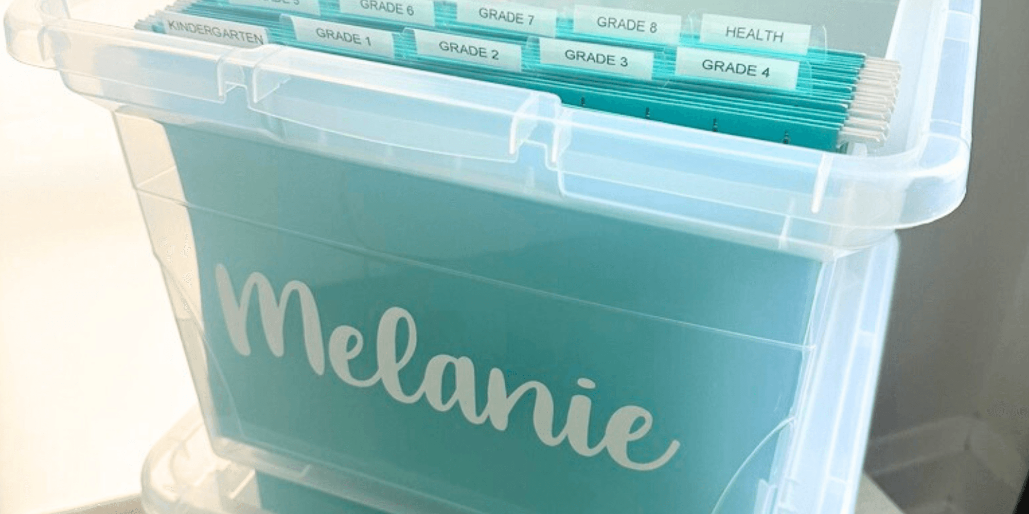 Personalized memory bin labelled Melanie holding tabbed school-grade files
