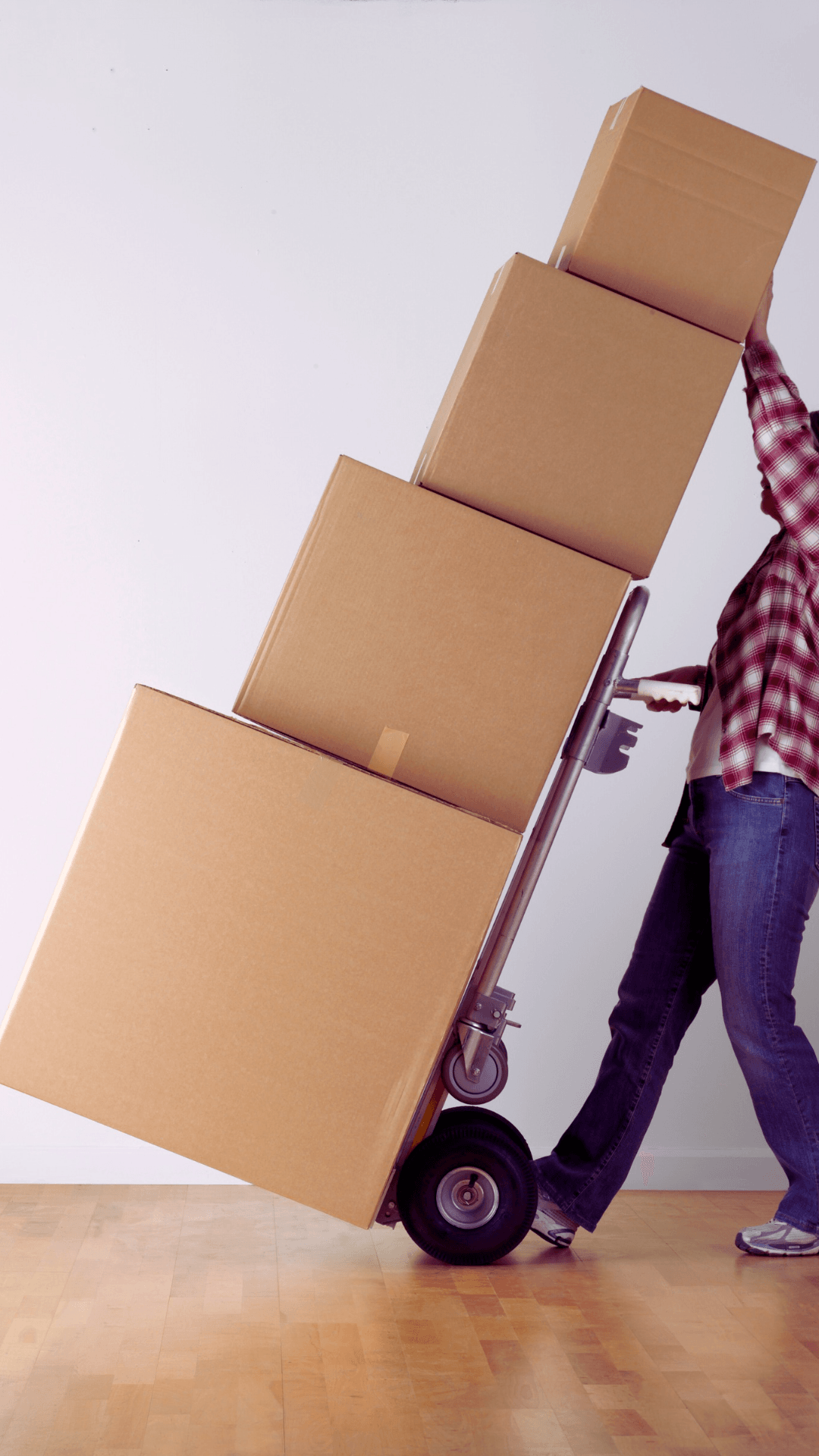 Person wheeling a stack of moving boxes on a hand truck