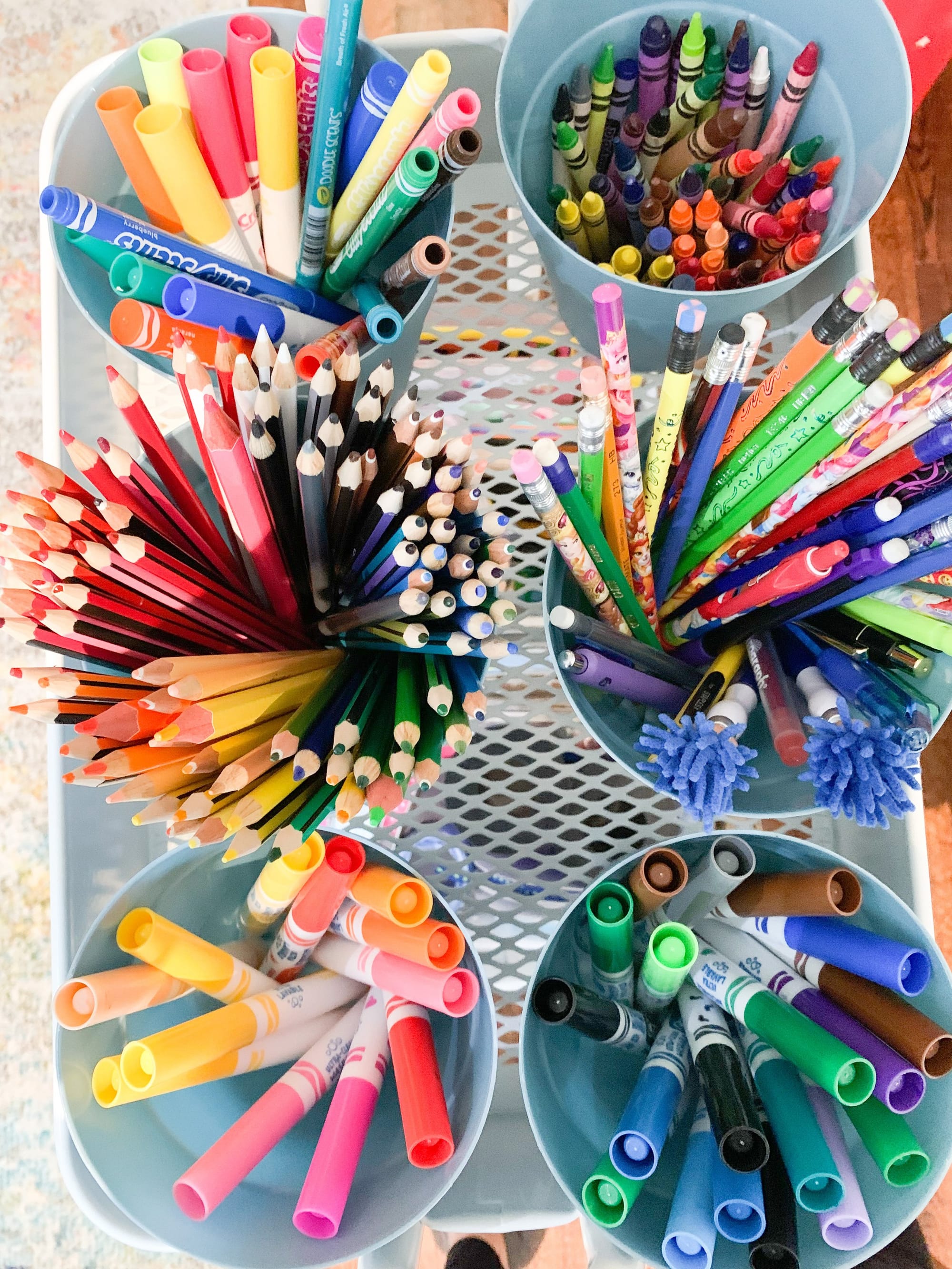 Art caddy with markers and pencils sorted by colour