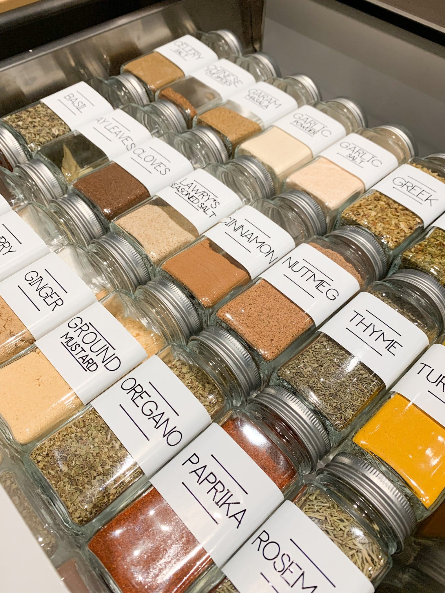Organized spice drawer with matching labelled glass jars